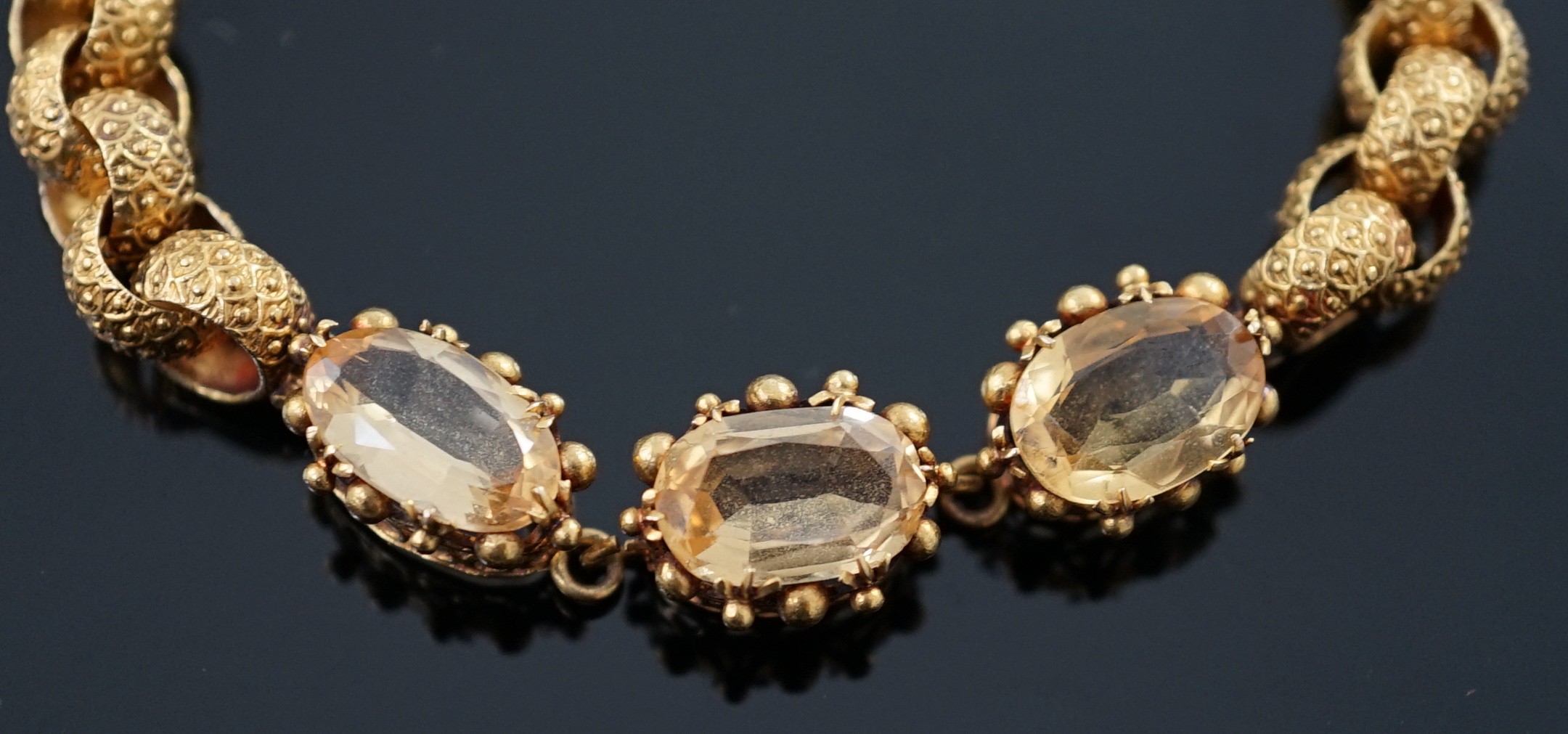 A 19th century cannetille work gold and four stone oval cut citrine set circular link bracelet